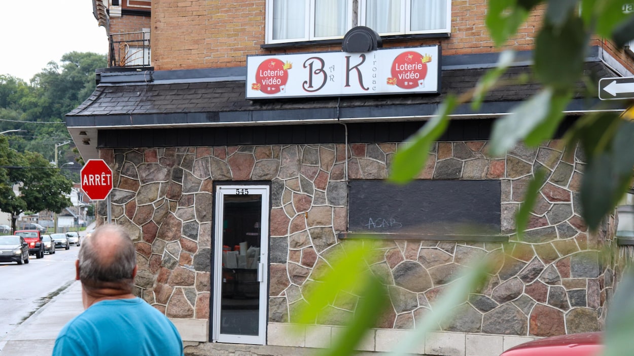 Un homme passe devant le Bar le Kirouac.