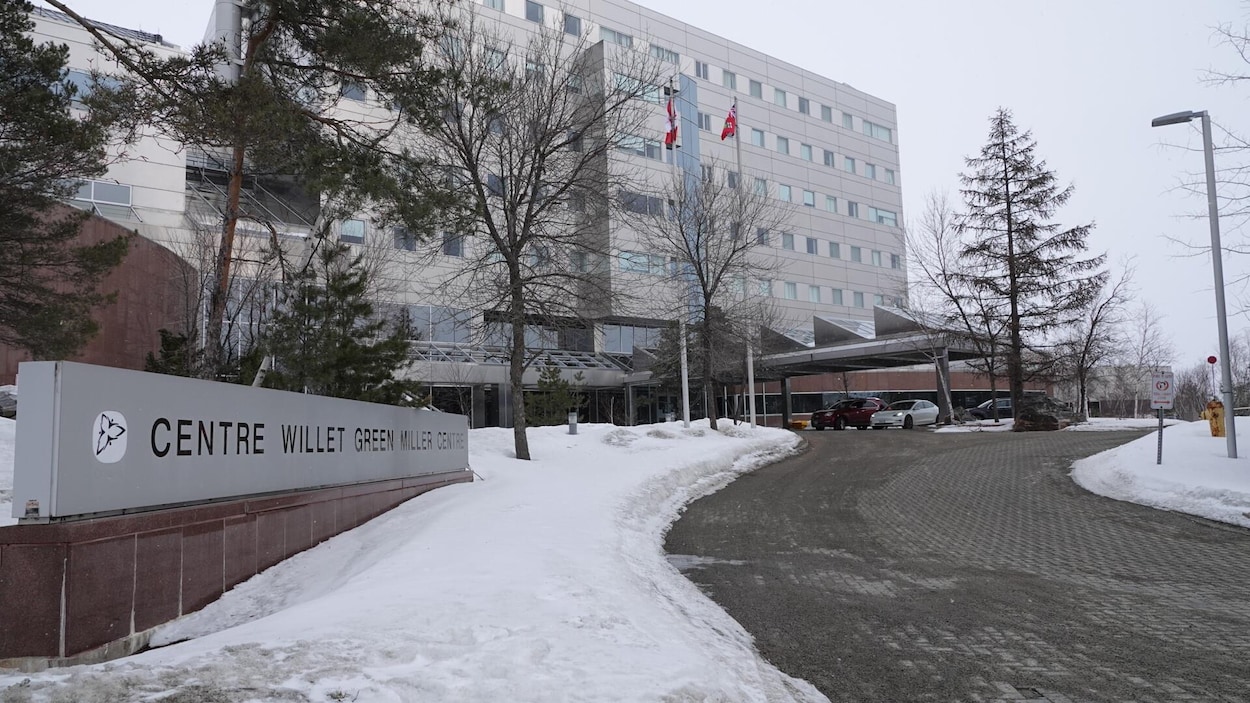 Un immeuble gris métallique avec des bancs de neige