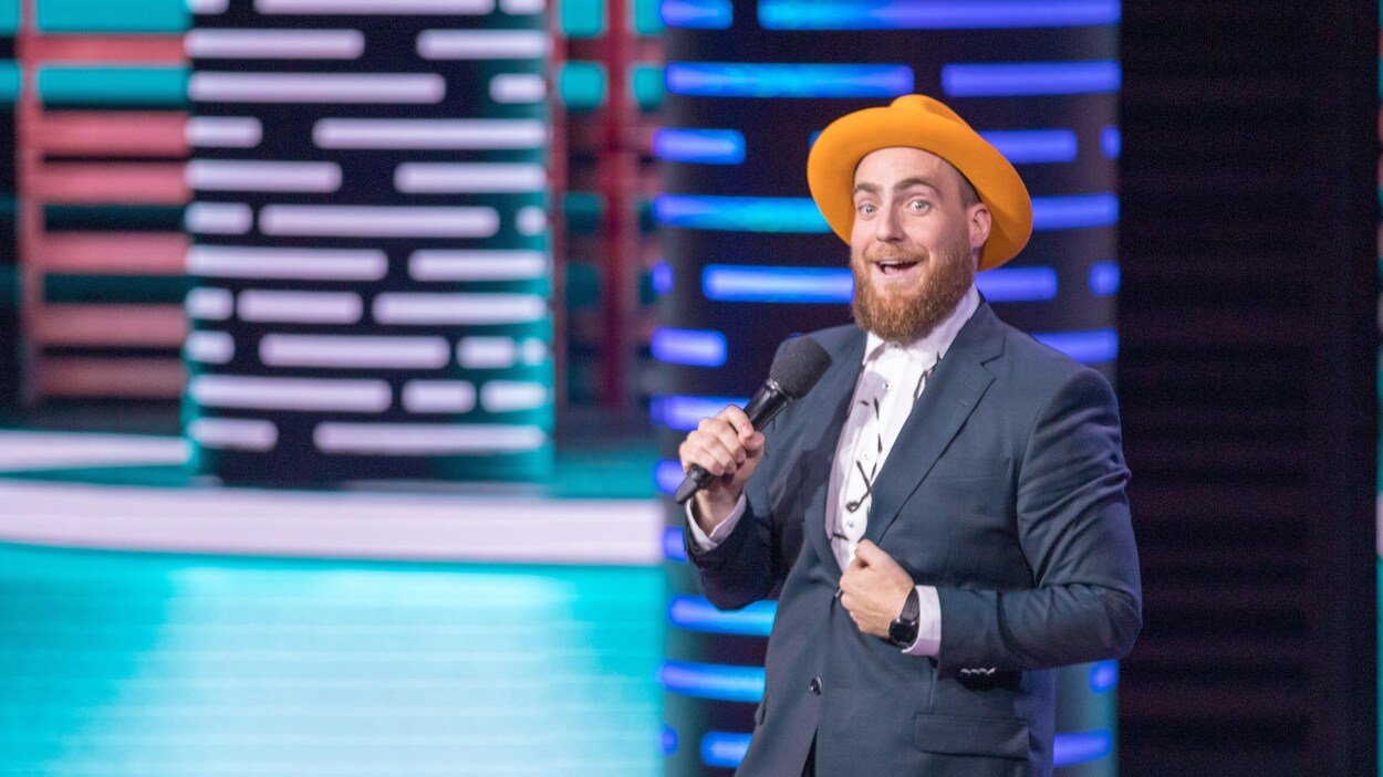 L'homme est sur scène et porte un chapeau.