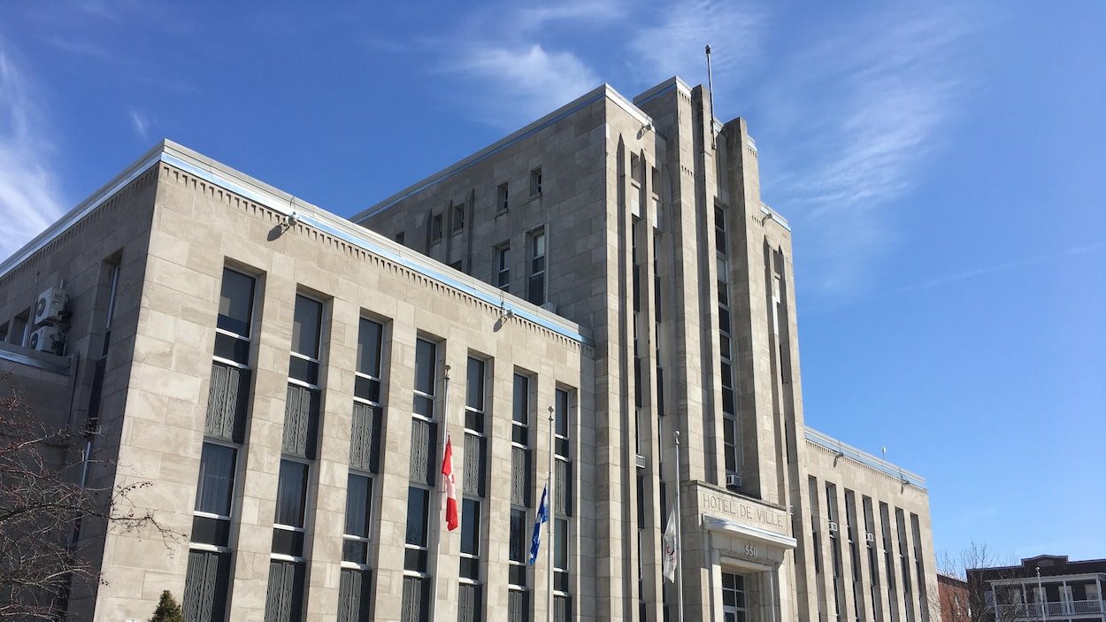 Drapeaux en berne devant un hôtel de ville.