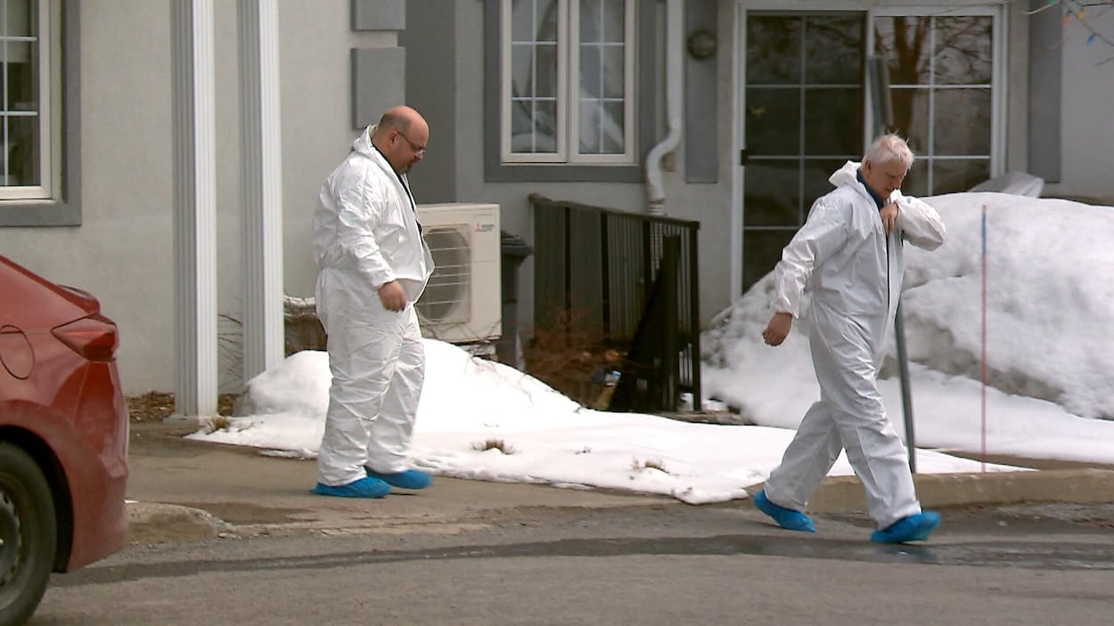 Des hommes vêtus d'une combinaison de protection sortent du Manoir de Courville, une résidence privée pour aînés de Québec.