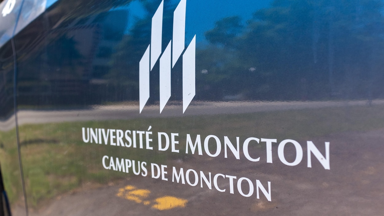 Le logo de l'Université de Moncton, campus de Moncton, imprimé sur le côté d'une voiture.