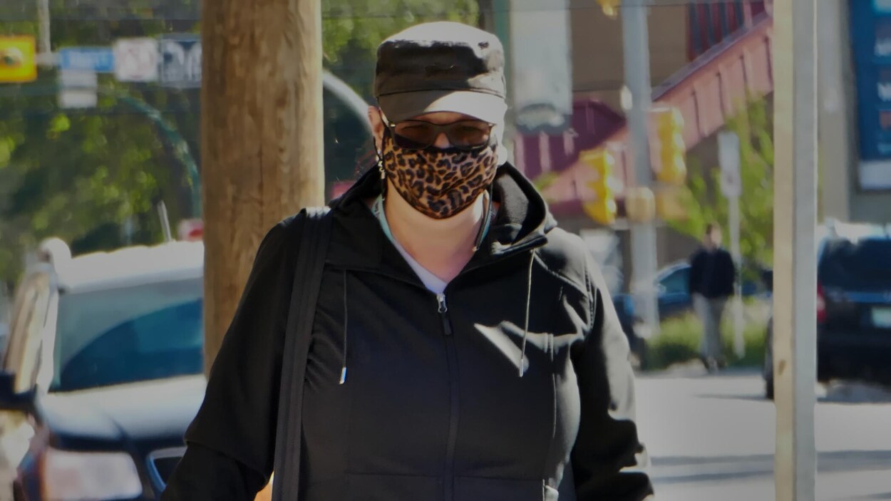 Une femme portant un masque marche dans les rues de Regina (archives).