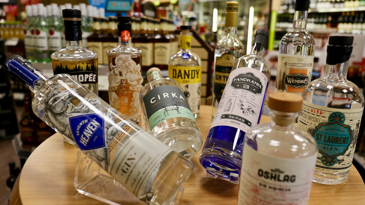 Des bouteilles de boissons alcoolisées diverses sur un comptoir dans une SAQ.