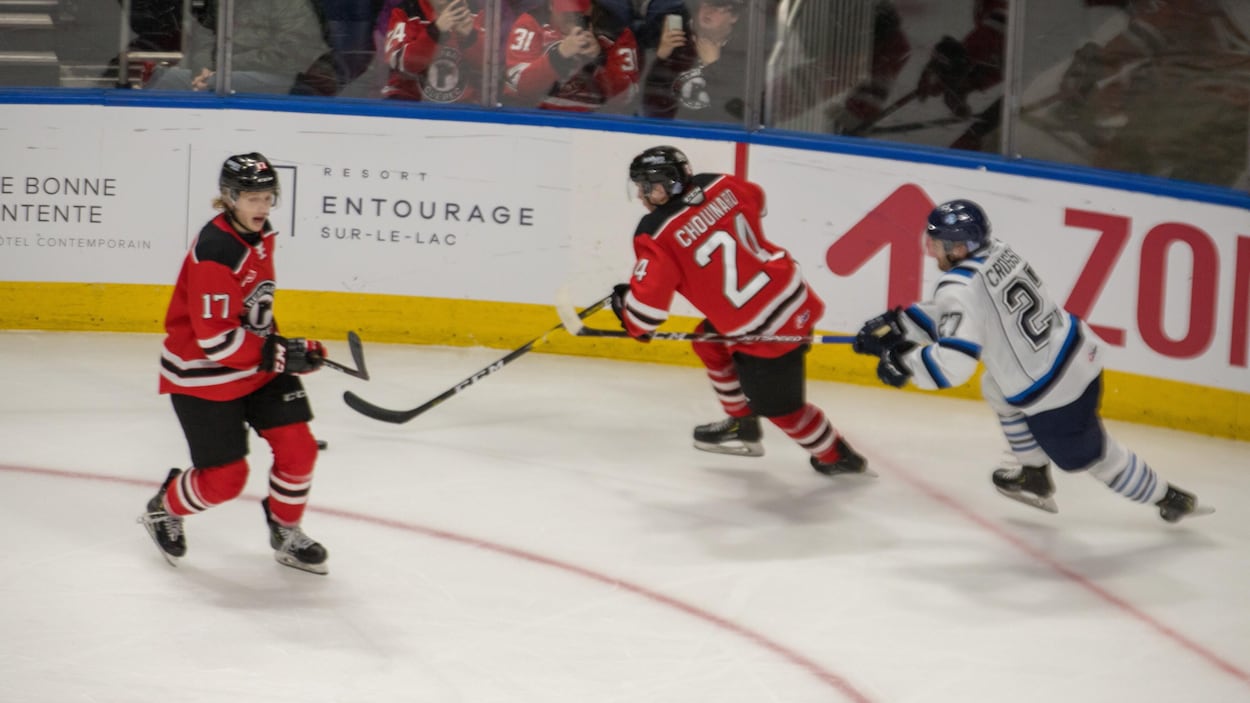 Des joueurs de hockey se disputent la rondelle.