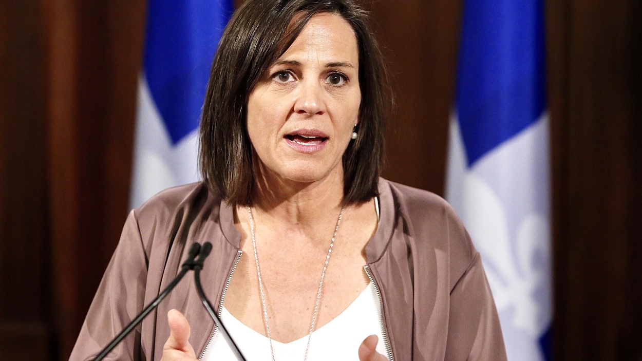 Elle parle devant un micro en point de presse
