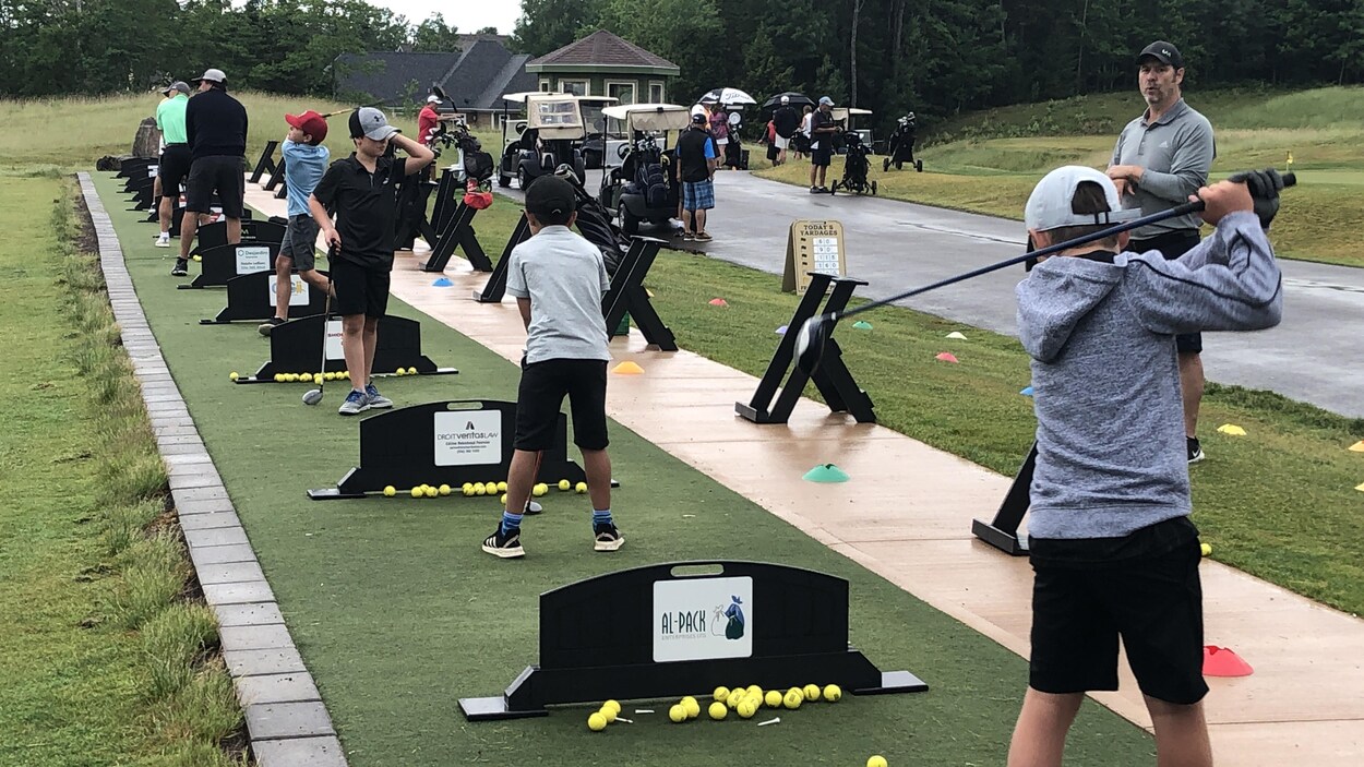De jeunes golfeurs s'élancent sur les tertres de départ d'entraînement.