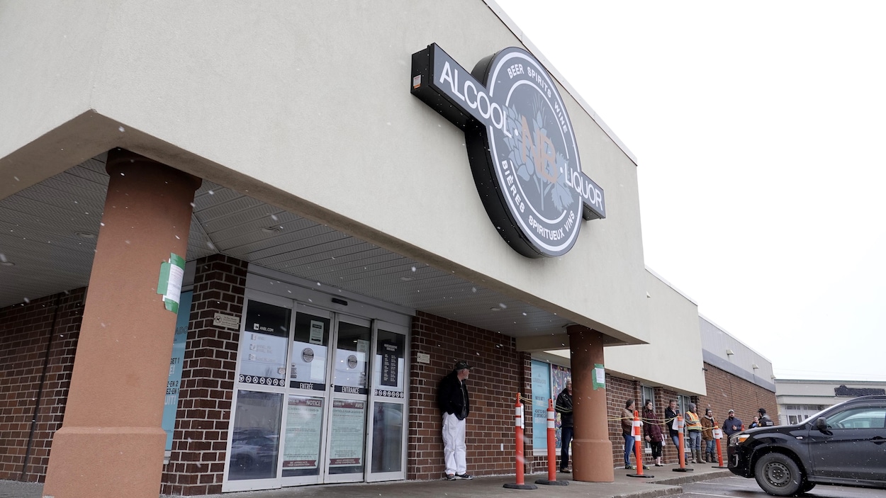 Une dizaine de personnes attendent leur tour de pouvoir entrer dans le magasin.