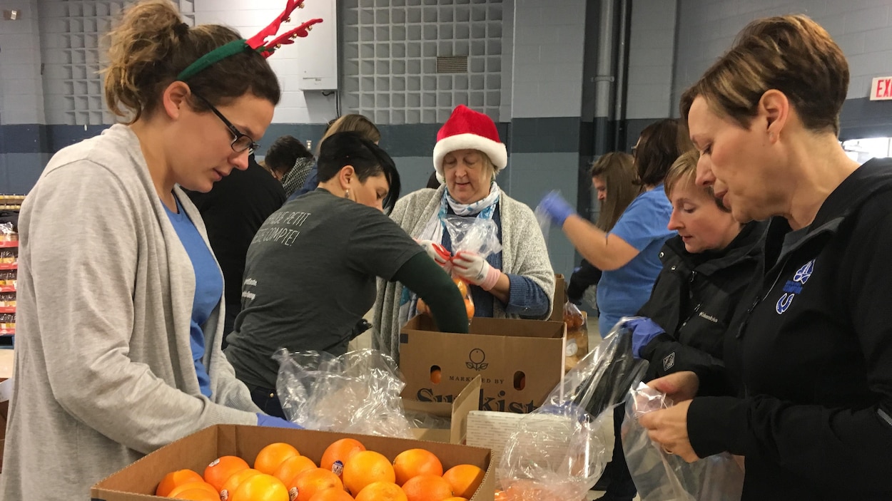 Des personnes trient des aliments dans des caisses.