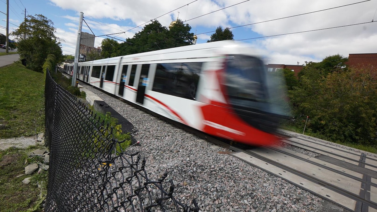 Le train passe à toute vitesse sur les rails.