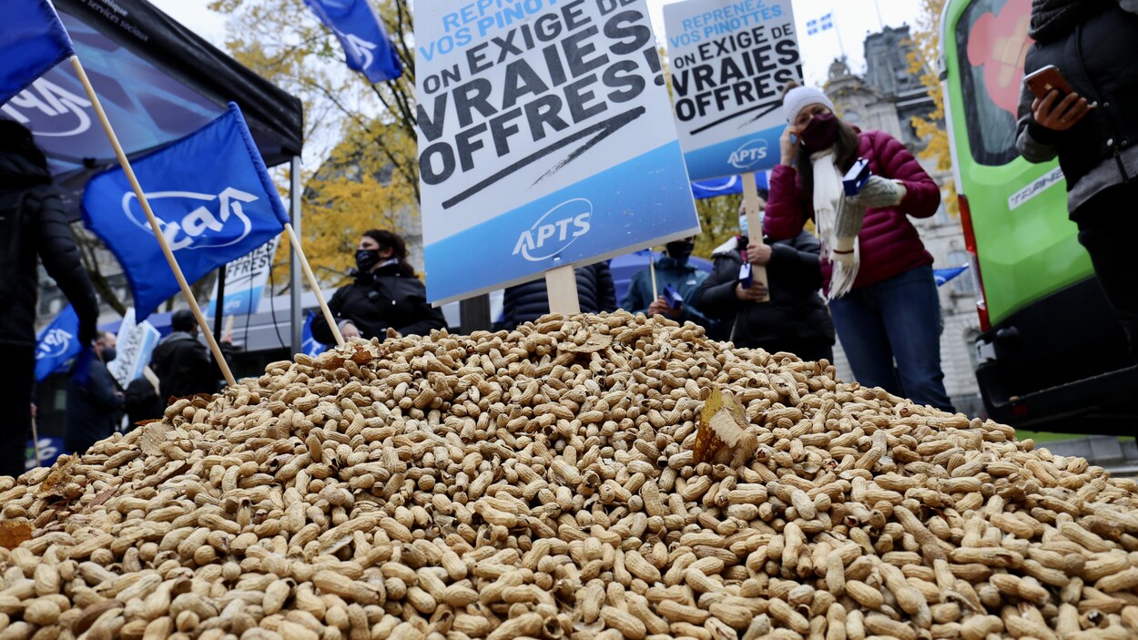 Un tas d'arrachide par terre, avec des affiches syndicales