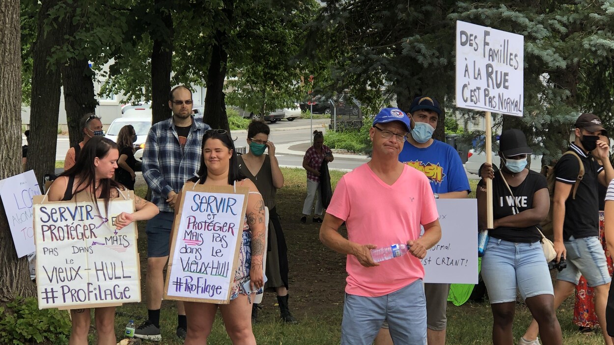 Des manifestants contre l'itinérance brandissant des pancartes.