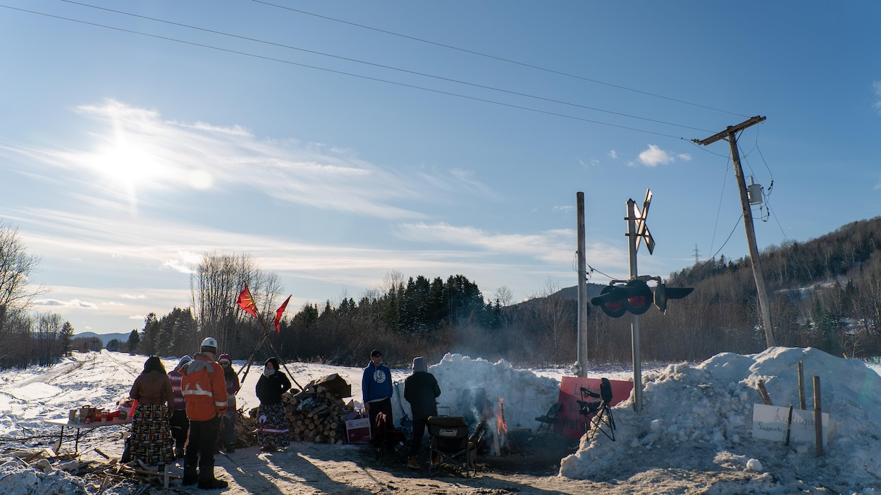 Une demi-douzaine de personnes discutent au campement des manifestants.