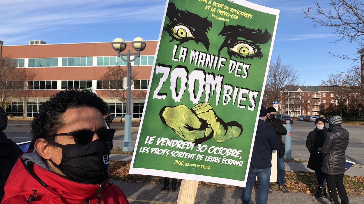 Un homme manifeste avec une affiche en main.