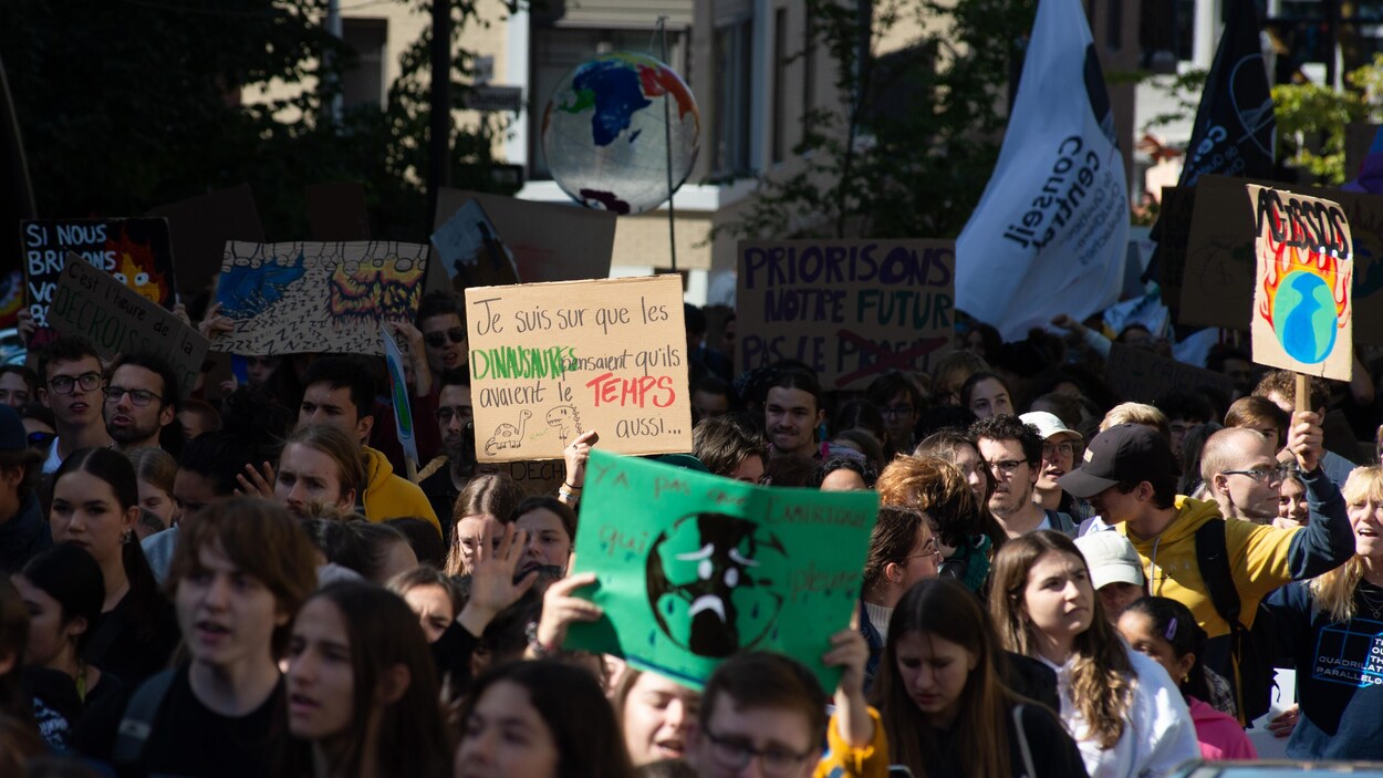 Des jeunes qui manifestent en tenant des pancartes.