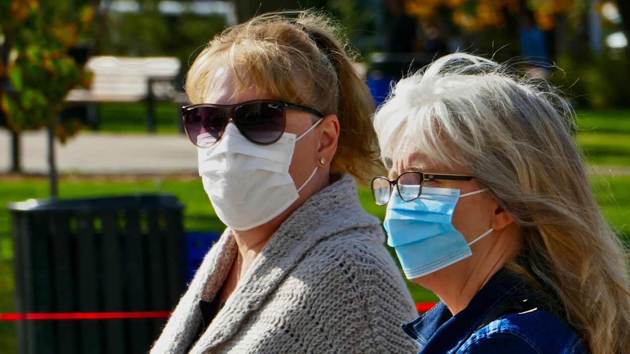 Des gens portant des masques au marché des fermiers de Regina en automne.