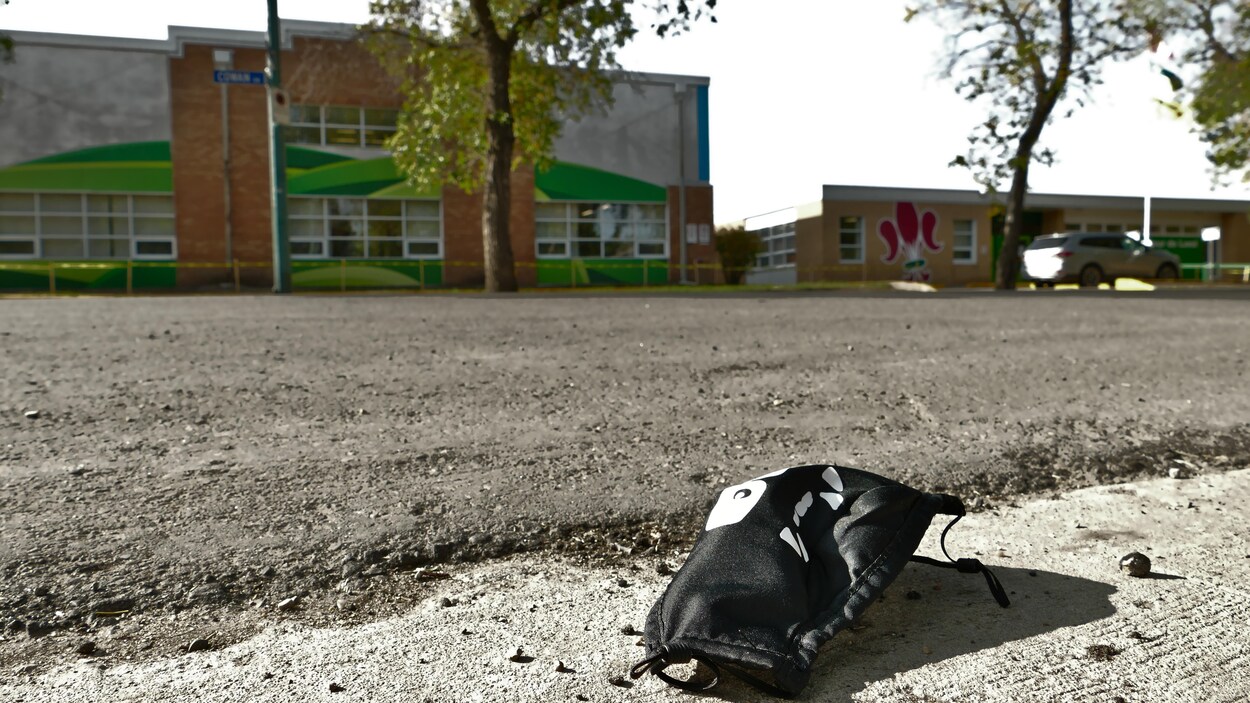 Un masque noir pour enfant est par terre dans la rue devant l'École élémentaire Monseigneur-de-Laval à Regina.