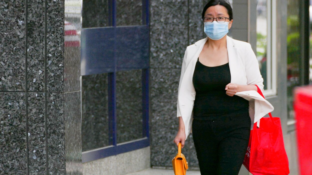 Une femme portant un masque marche dans les rues de Saskatoon.