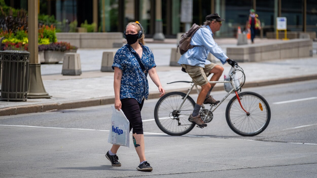 Une femme portant le masque traverse la rue à Ottawa.