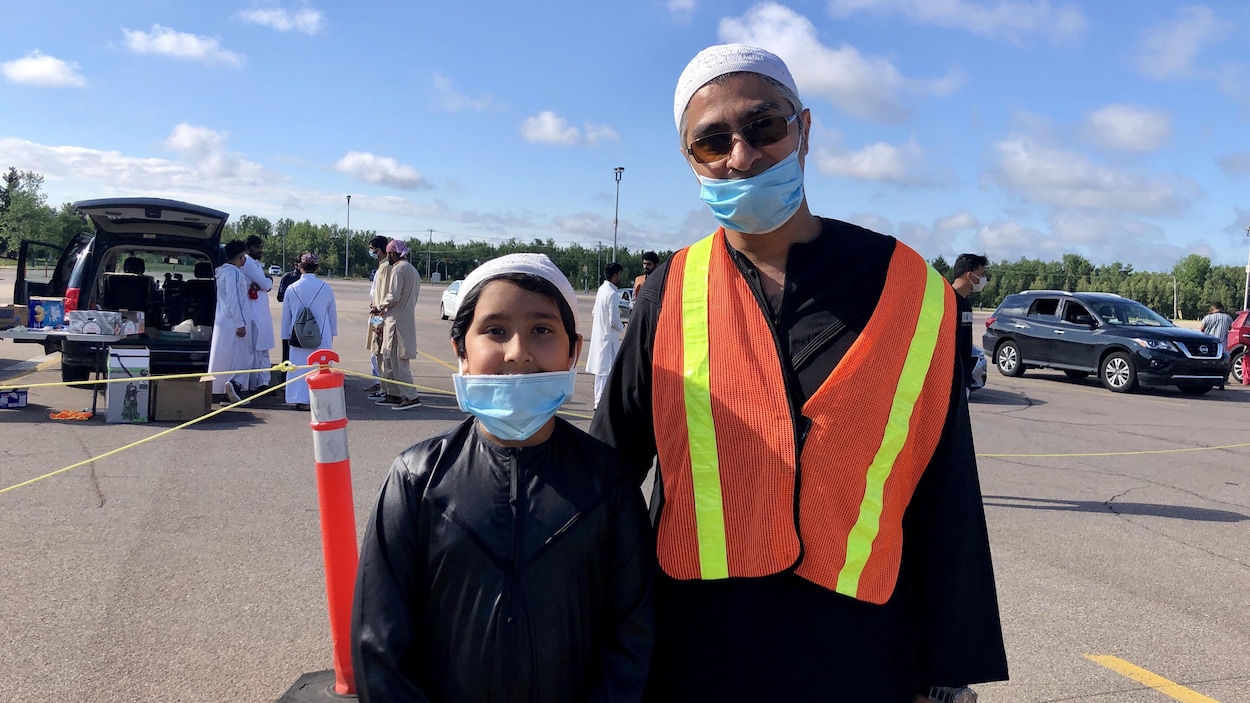 Un homme et son fils debout devant quelques autres participants.