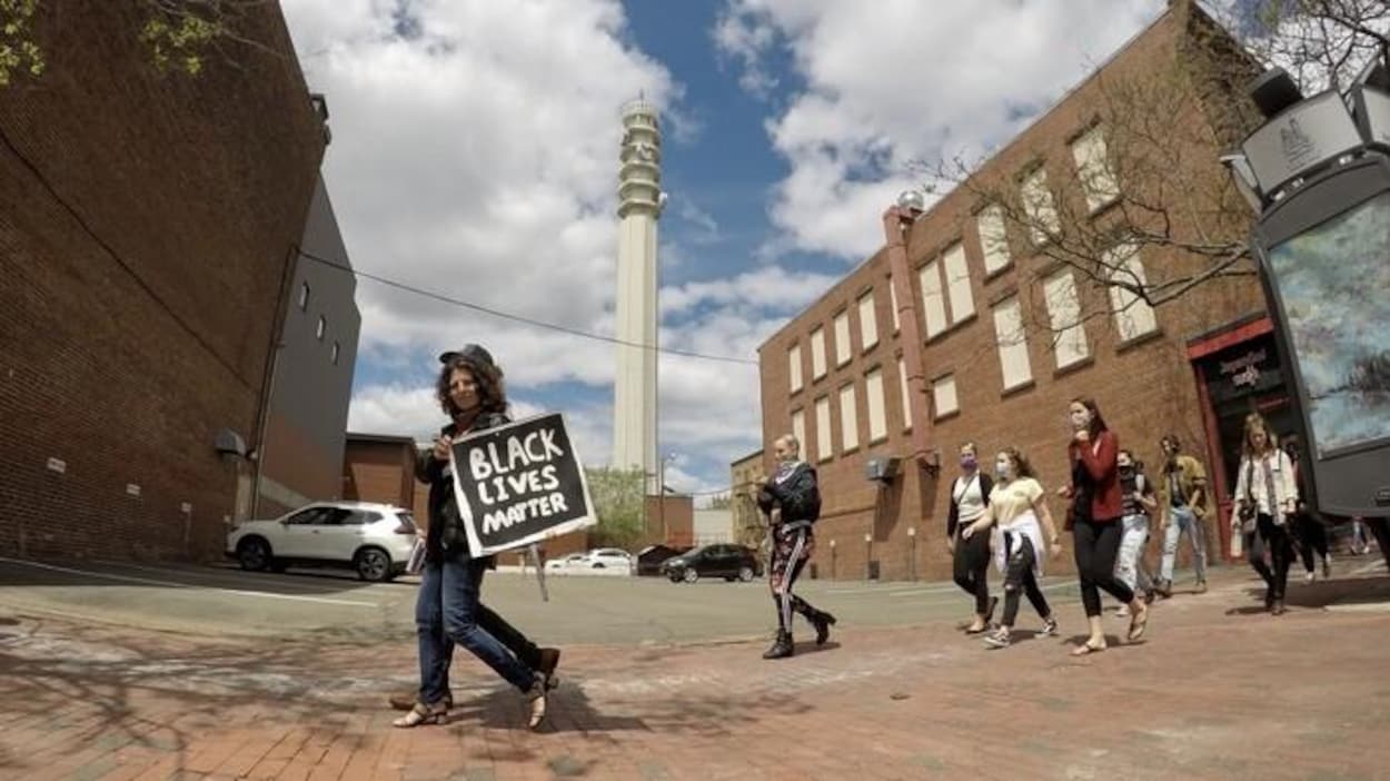 Un jeune homme avec une pancarte BLACK LIvES MATTER