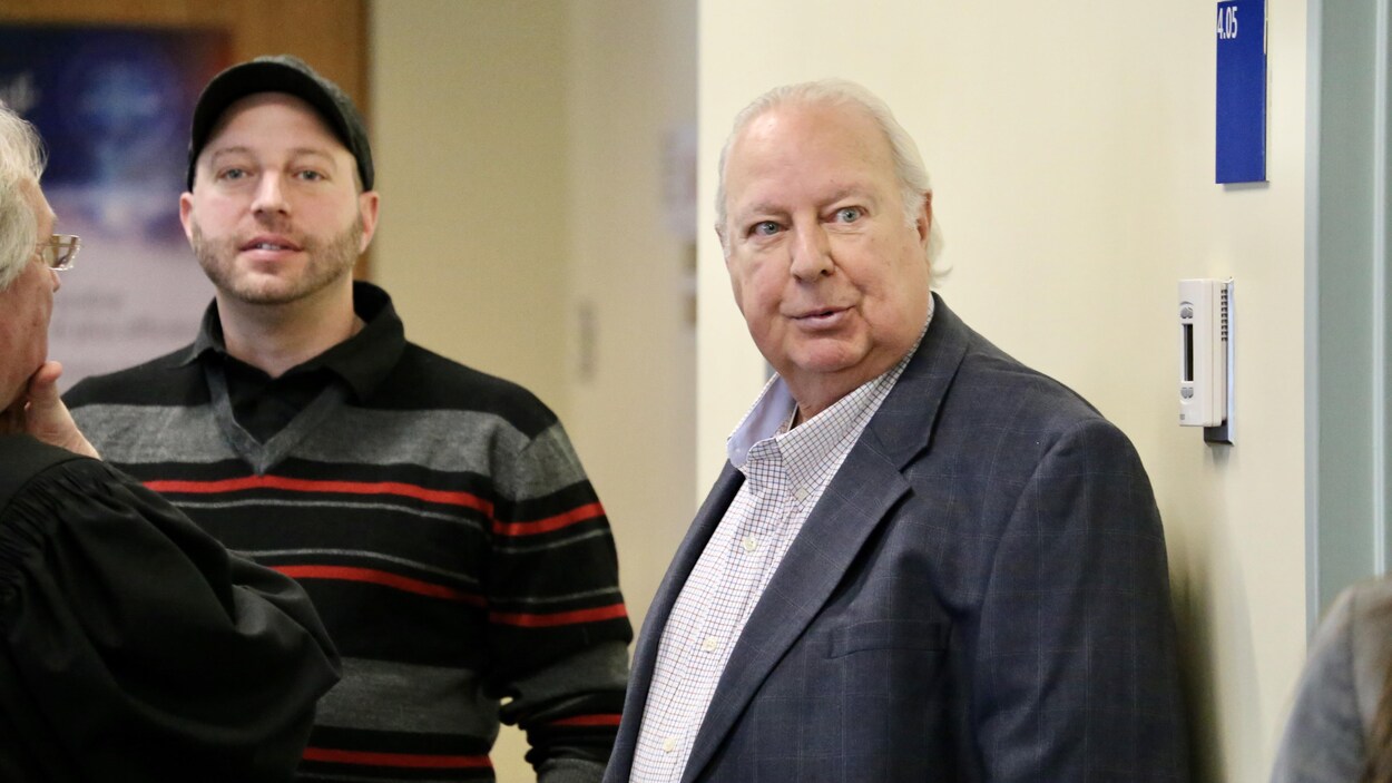 Deux hommes un à côté de l'autre, celui de gauche est plus jeune. Ils sont au palais de justice