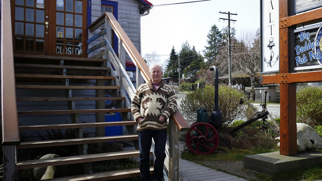 L'homme de 68 ans pose devant un bâtiment qu'il possède.