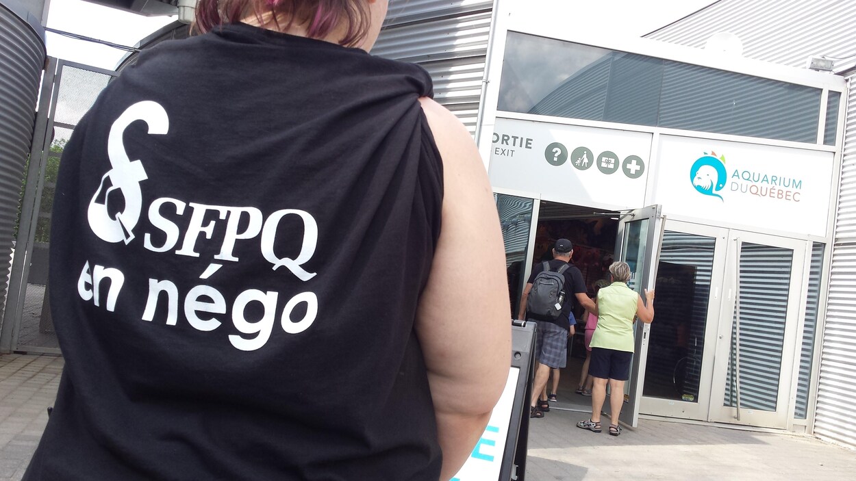 Une employée de l'Aquarium du Québec portant le gilet noir.