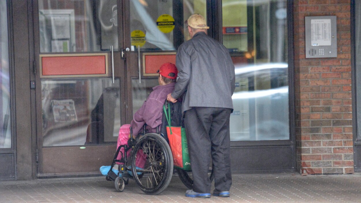 Un couple âgé entre dans un bâtiment.