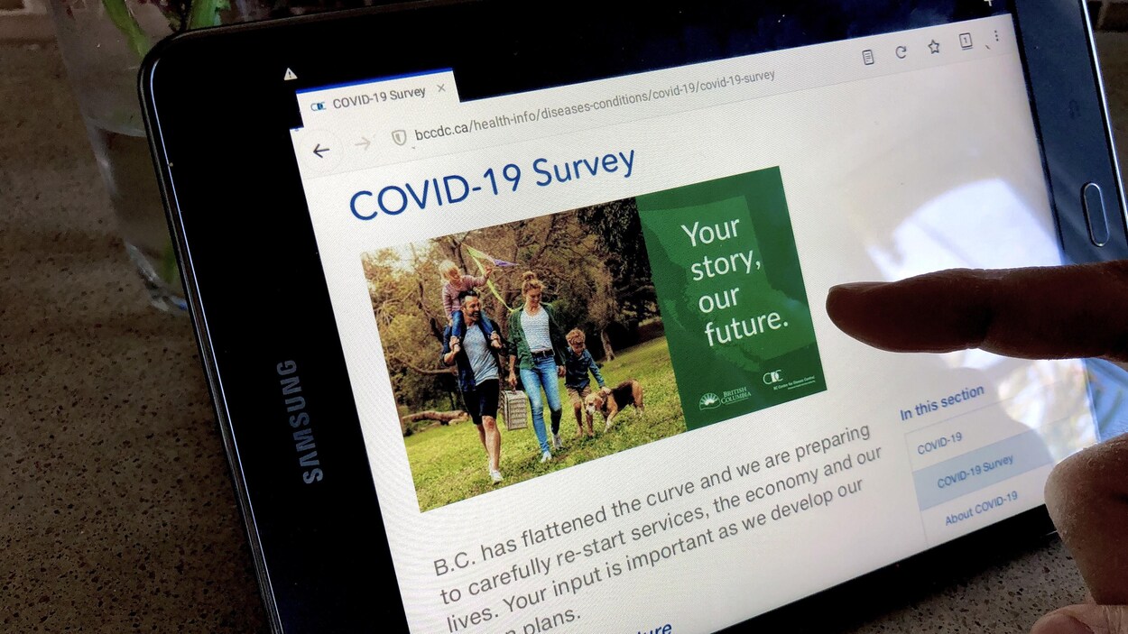 Une personne parcourt la page de présentation du sondage sur sa tablette.