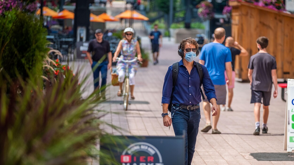 La rue Sparks à Ottawa, en été, avec des passants masqués.
