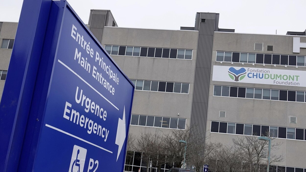 Une enseigne pointant l'entrée de l'urgence et le bâtiment de l'hôpital.
