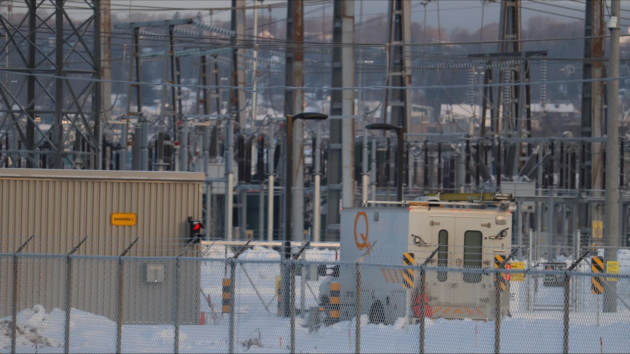 Un camion d'Hydro-Québec devant des installations électriques, en hiver