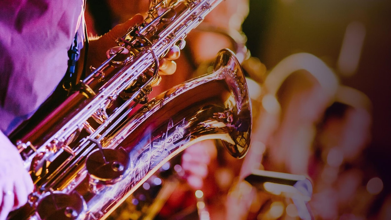 Un saxophone dans un éclairage chaleureux, rose et violacé