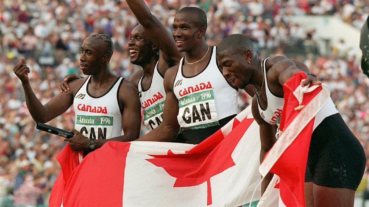 Ils tiennent le drapeau canadien et sourient.