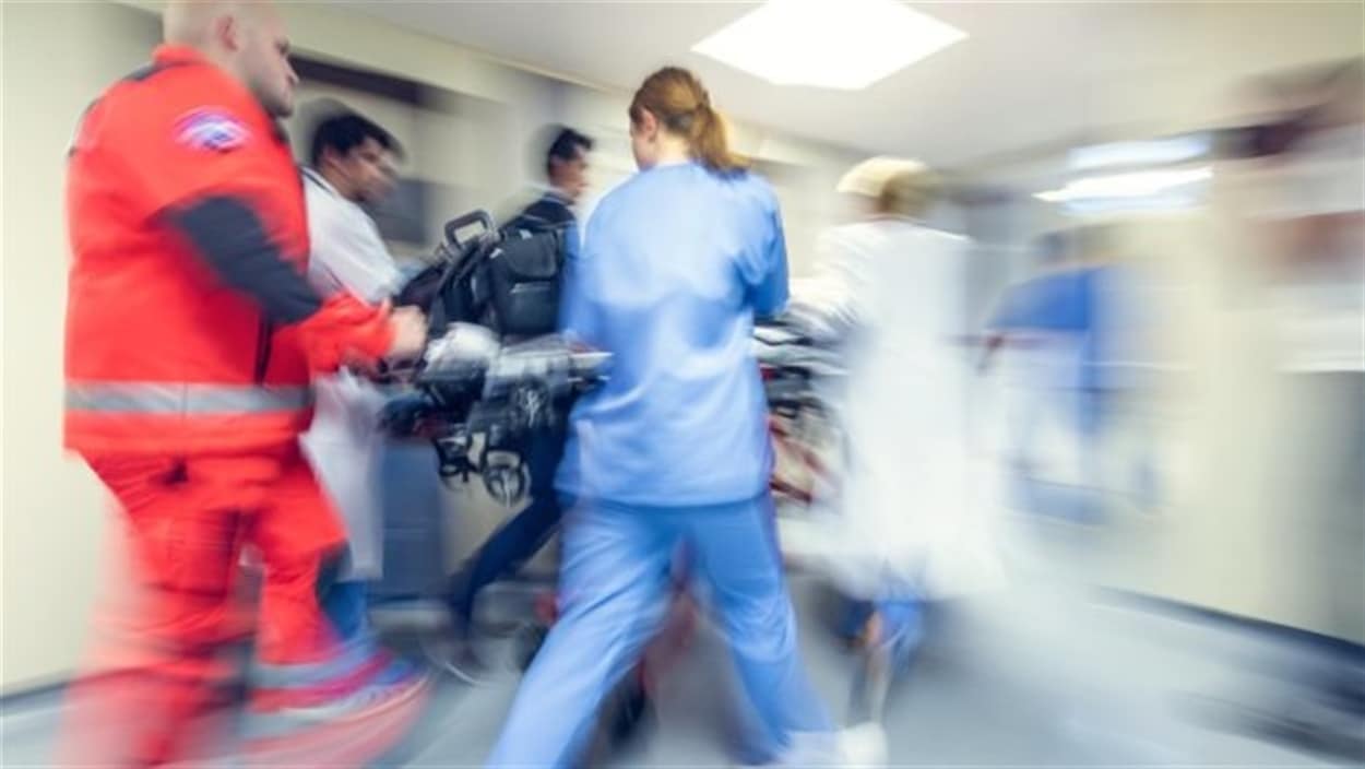 Une équipe des urgences transporte un patient sur une civière. Une équipe des urgences transporte un patient sur une civière.
