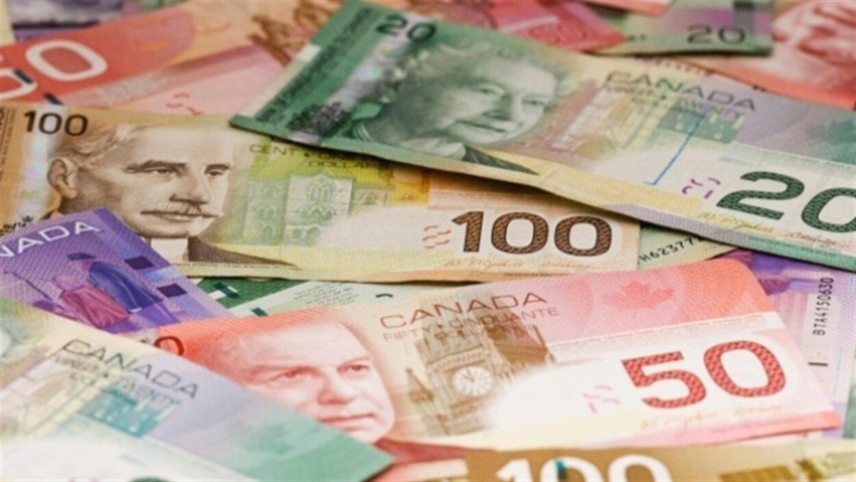 Des billets de 10, 20, 50 et 100 dollars empilés.