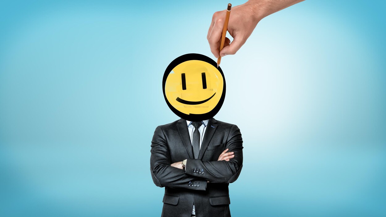 Un homme d'affaires dont la tête est redessinée pour ressembler à un « bonhomme sourire ».