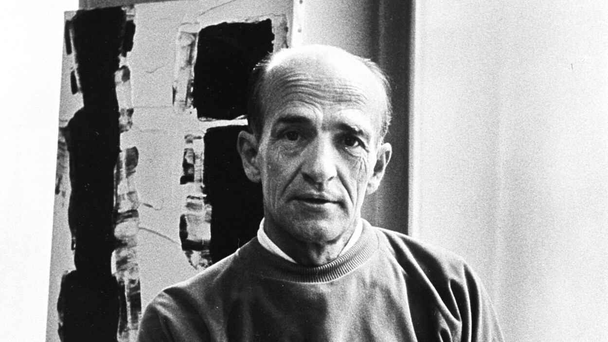 À l'intérieur, le peintre québécois Paul-Émile
Borduas est assis sur un banc, devant une
toile (peinture) accrochée au mur.