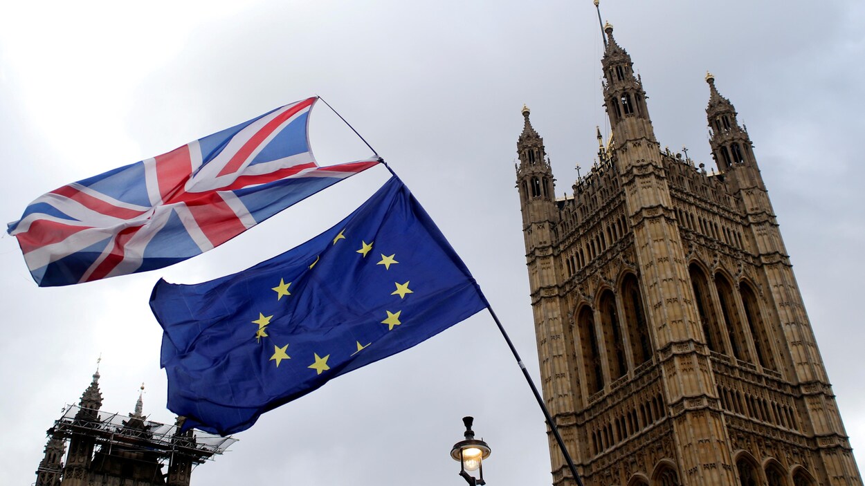 Le drapeau de l'Union européenne et le drapeau britannique brandis devant la tour Big Ben.
