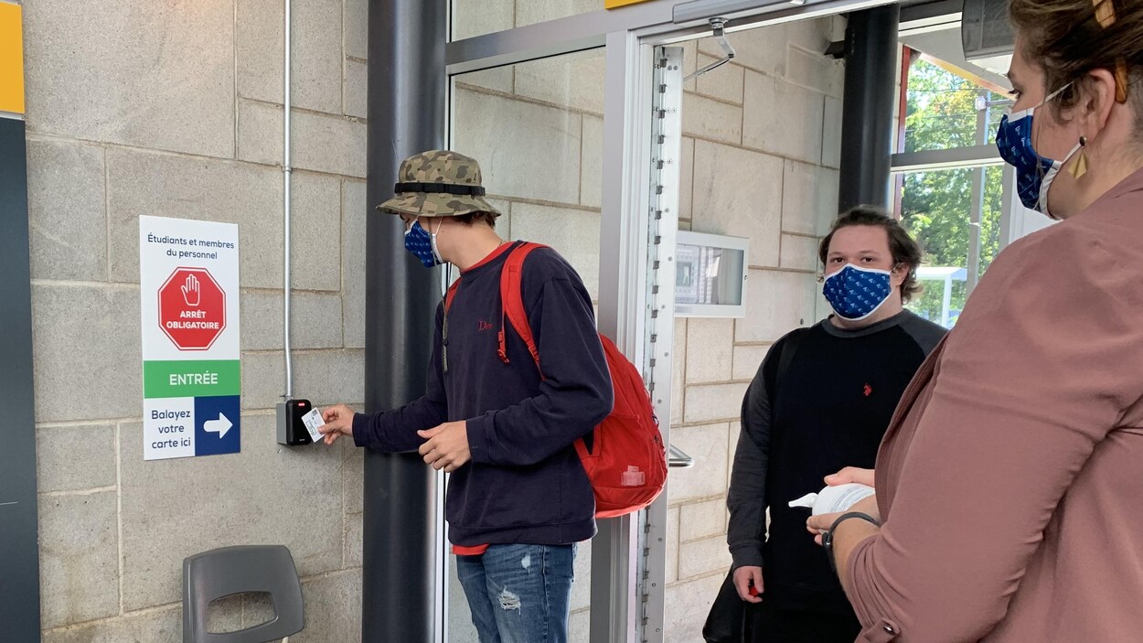 Un étudiant passe sa carte devant un lecteur numérique