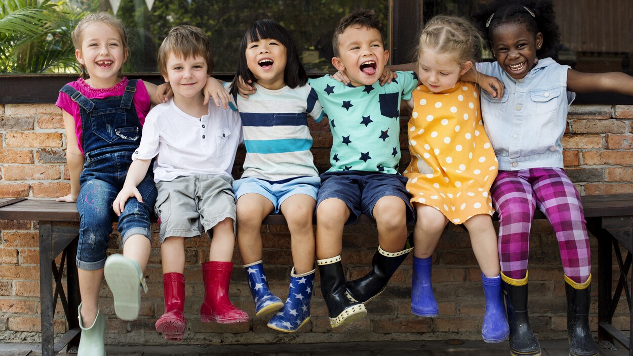 Six enfants sont assis sur un banc.