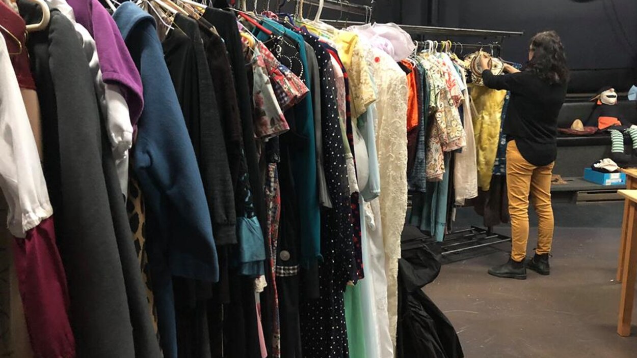 Une femme dans un entrepôt de costumes de théâtre