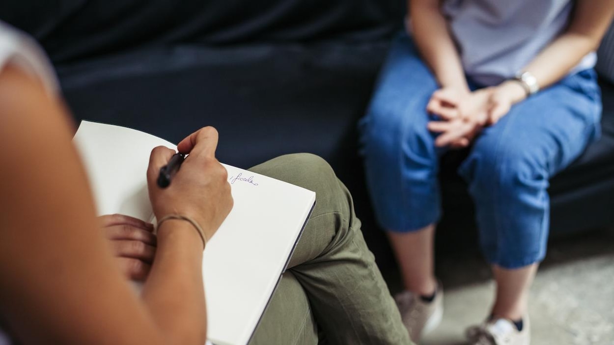 Une femme discute avec une psychologue durant une séance de psychothérapie.