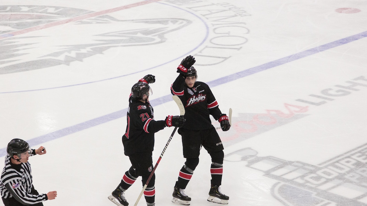 Deux joueurs de hockey célèbrent un but lors d'un match de hockey.