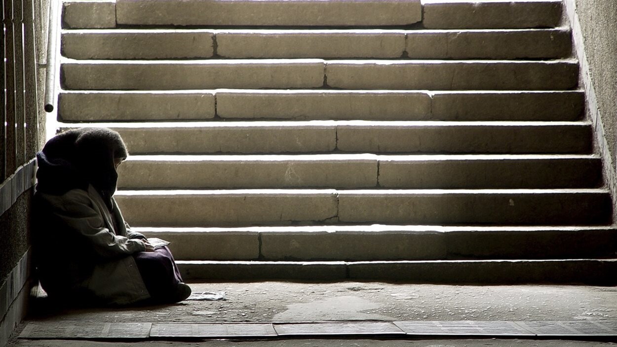 Un sans-abri au bas d'un escalier Un sans-abri au bas d'un escalier