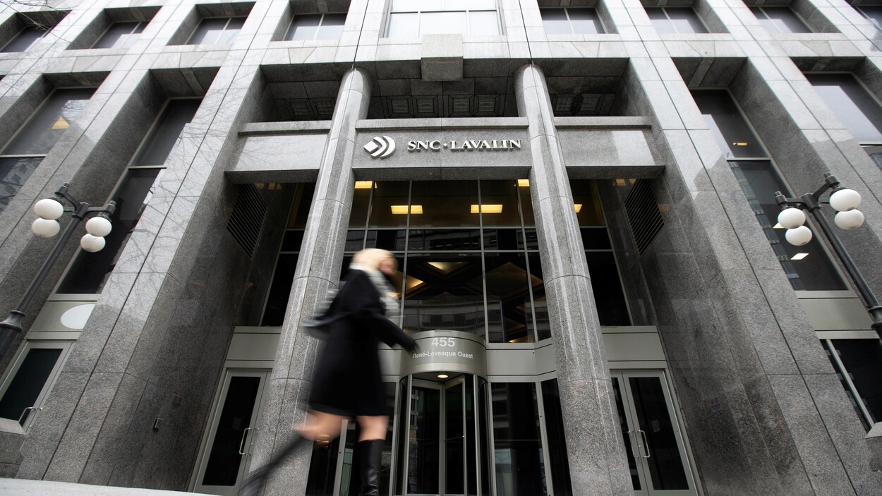 Une piétonne passe devant le siège social de SNC-Lavalin à Montréal.