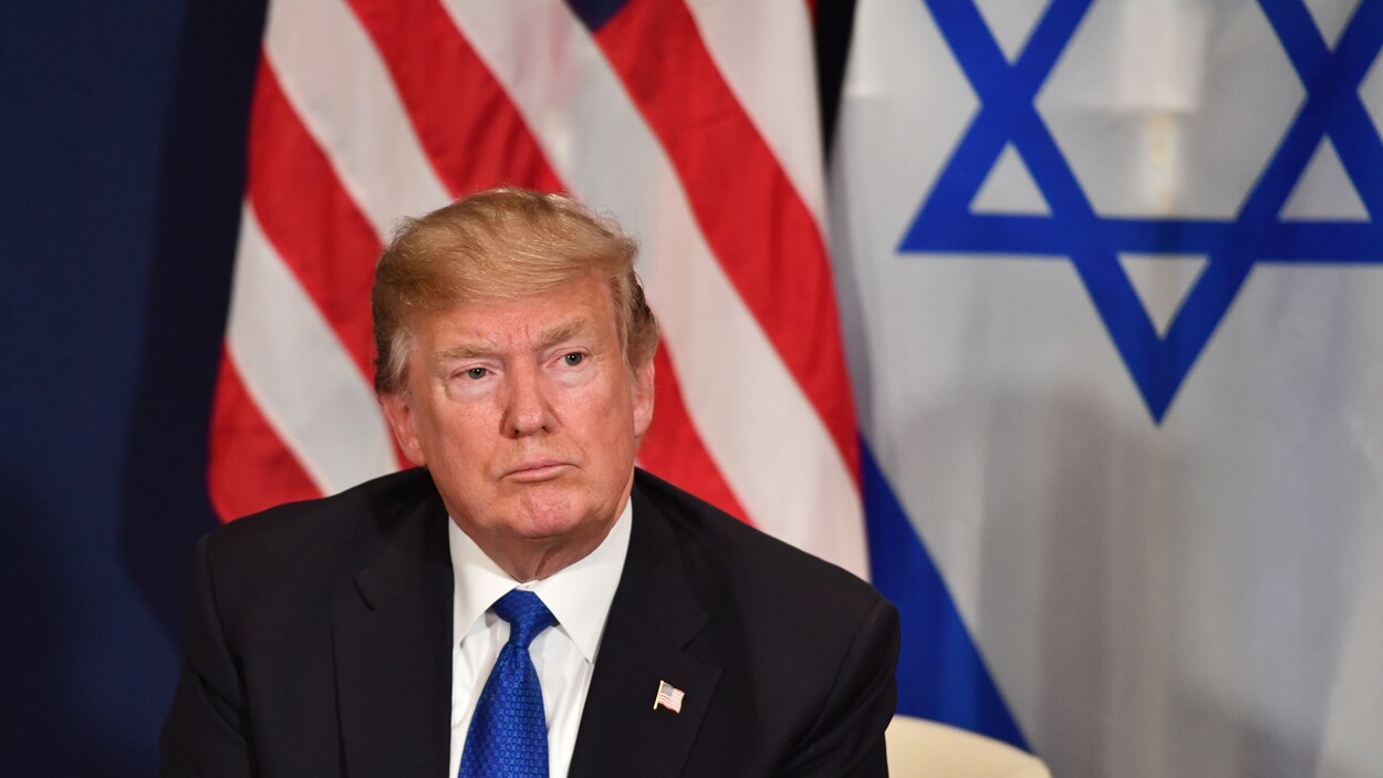Le président Trump en avant des drapeaux des États-Unis et d'Israël