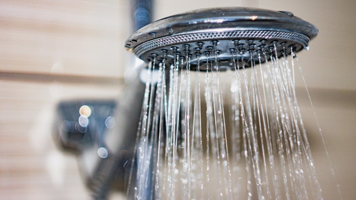 De l'eau coule d'une pomme de douche.