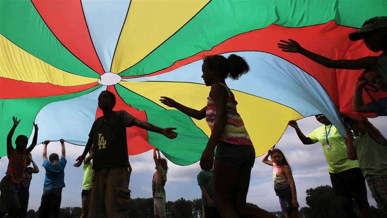 Des enfants jouent sous un grand chapiteau de tissu coloré. Des enfants jouent sous un grand chapiteau de tissu coloré.
